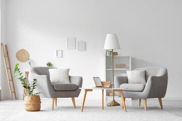 Comfortable armchairs and wooden coffee table in interior of room