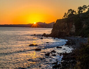 Fototapeta premium Serene Sunset Over Rocky Shoreline with Vibrant Sky Colors