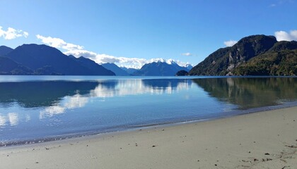 Fototapeta premium Calm Lake Reflecting Mountains and Sky under Clear Blue Daylight