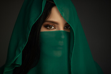 Naklejka premium Arabian Woman in Green Veil With Mysterious Eyes and Traditional Beauty
