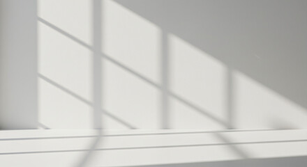 Section of a white wall with shadows cast on it, likely from a window with multiple panes. The shadows create a geometric pattern on the wall. The lighting suggests a bright, possibly sunny day.
