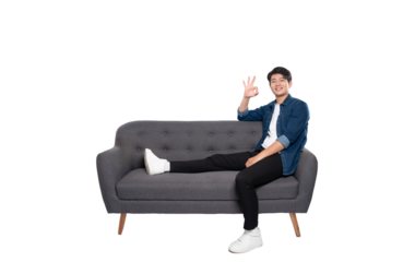 Full body image of young Asian man posing on sofa on PNG background	