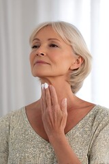 senior woman applying skincare cream to neck