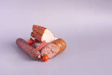 Various types of sausages and aromatic meat products close-up on a light background place for text