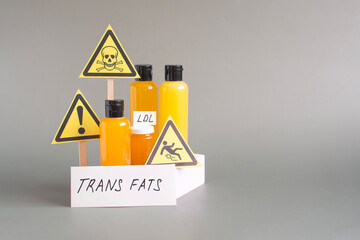 The concept of the danger of products containing trans fats. Containers filled with various trans...