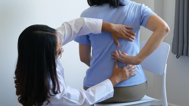 Asian female patient receives physical therapy with a spine physiotherapist, consultation and rehabilitation guidelines for the back, physical therapy, health from experts