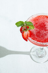 Close up refreshing Strawberry Daiquiri Cocktail Garnished with Mint in Bright Lighting