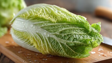 Napa cabbage on a wooden cutting board with scattered salt.