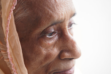 Elderly woman gazing thoughtfully near window light