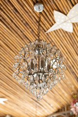 A crystal pendant light mounted on the ceiling made from bamboo.