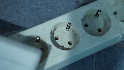 Close-up of a Dirty and Worn-Out Multi-Plug Power Strip