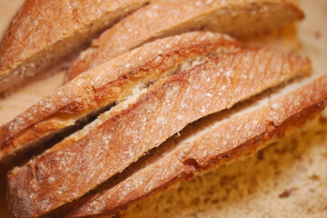 Freshly baked bread sliced on wooden board