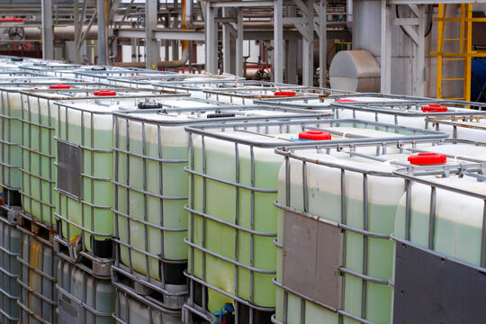 Stacked IBC totes, industrial chemical storage, outdoor setting	