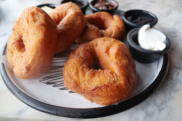 Delicious Golden Fried Pastries with Cream and Jam on a Decorative Plate