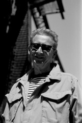 Senior man smiling wearing sunglasses in monochrome analog film photography