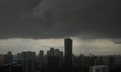 Obraz premium High Angle Of A City Skyline Obscured By Dark Sky, Overcast Clouds, Hinting At Rain