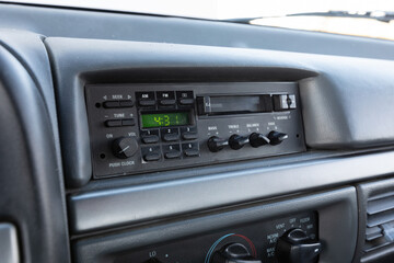 Close-up dashboard details of an older American pickup truck with 4x4 drivetrain. Features include control knobs, radio unit, climate panel, and gauges, all photographed in clean daylight conditions