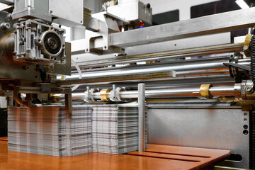 Advanced paper feed mechanism operates glue spreading machine in a bustling production facility