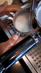 Close up of barista steam milk to make froth foam	