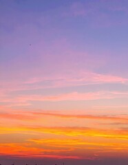 Fototapeta premium A breathtaking sunset over the tranquil ocean, with vibrant hues of orange and pink reflecting on the water, silhouetting small boats gently bobbing on the waves.