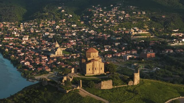 Aerial view of Jvari Monastery and Mtskheta cityscape at sunrise in Georgia