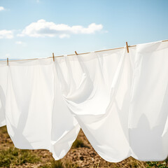 Flowing White Sheets Drying in the Gentle Wind on a Sunny Day