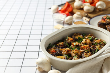 Stuffed mushrooms, towel and vegetables on light background, space for text