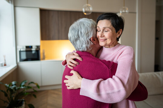 Happy calm elderly couple hugging affectionately, cuddling tight. Loving wife holding spouse close share joy, good news, strong emotional bond, mature love in stable family unity, old married couple