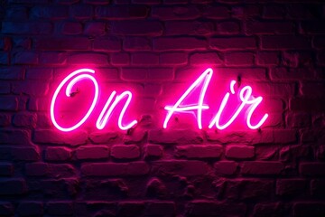 Pink neon sign that says "On Air" on a brick wall.