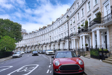 Elegant crescent shaped street in London, townhouses with portico entrances and parked cars
