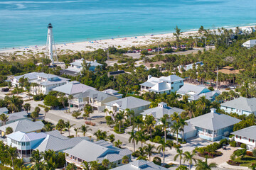 Aerial view of wealthy waterfront neighborhood. Expensive mansions between green palm trees on Gulf of Mexico shore in island small town Boca Grande on Gasparilla Island in southwest Florida, USA © bilanol