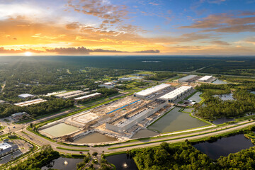 Fototapeta premium Industrial warehouse construction site. Assembling of metal and concrete frame of new logistics center in North Port, Florida