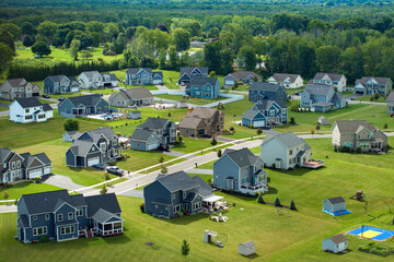 Low-density two story private homes with large lot size and green grassy lawns in summer season. Rural residential suburbs with upscale suburban houses outside of Rochester, New York © bilanol