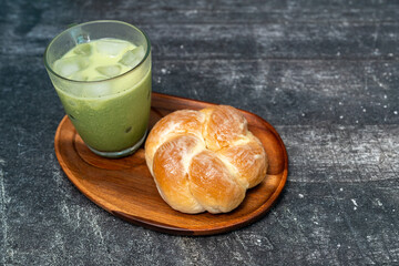 Green tea, matcha latte with butter bread on a wooden tray