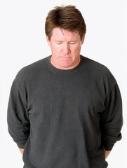 Obraz premium A man looking down with a slight frown, medium closeup, isolate on white background