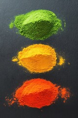 Colorful spice powders on dark surface