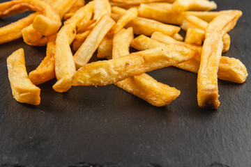 Crispy golden fries served on a dark slate surface