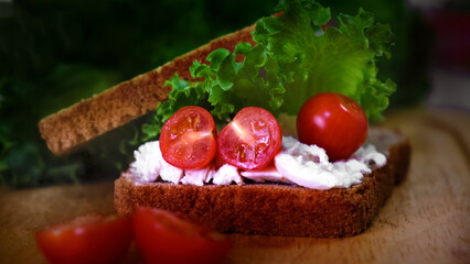 Club sandwich with salami, salad, vegetables, lettuce, cherry tomato, prosciutto, onion, spread...