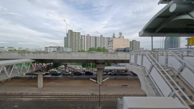 the SRT Red Line in Bangkok, Thailand, showing a modern electric train arriving at or departing from Bang Son Station. The elevated platform and railway infrastructure are clearly visible,= along.