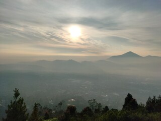 Golden sunrise over misty mountains, creating a peaceful and dreamy natural landscape view.