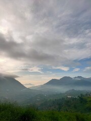 Misty morning mountains under dramatic skies, capturing the calm and mystery of nature’s dawn veil.