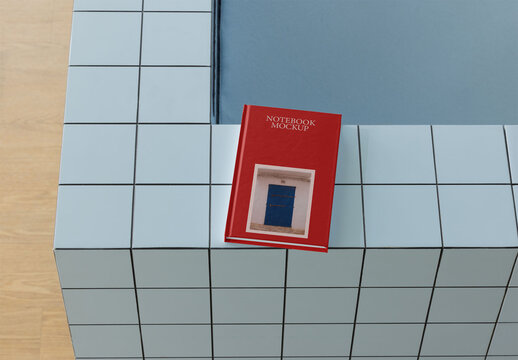 Mockup of Blank book resting on a blue tiled edge