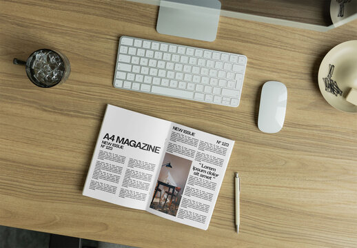 Open magazine template with two pages. Overhead view. A minimal workspace featuring a keyboard, mouse, and notebook.
