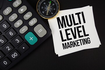 Multi Level Marketing text with compass and calculator on black background