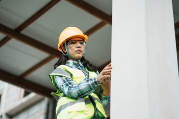 Construction worker inspecting column urban site photography daylight low angle safety and teamwork