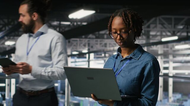 Portrait of joyful computer scientist in data center monitoring neural network LLM visualization. Upbeat woman in server farm overseeing rigs powering machine learning processes, camera B - Powered by Adobe