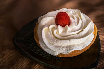 pastel relleno de queso adornado con crema y frambuesa