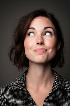 Woman displaying emotion with half-smile and raised eyebrow studio portrait dramatic lighting close-up facial expression
