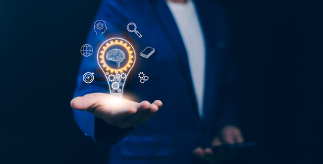 Concept of innovation, artificial intelligence, strategic business solutions. A hand hold a glowing light bulb with a brain and digital icons, new ideas, technology advance, and smart thinking future