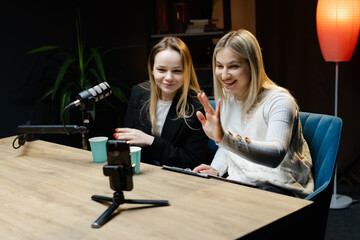 Two Content Creators Waving at Camera During Live Podcast Recording